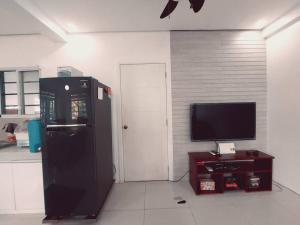 a kitchen with a black refrigerator and a tv at The Two-Bedroom Balcony House Tagaytay in Tagaytay