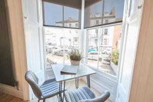 a table and chairs in a room with a large window at Ocean Pearl Whitby in Whitby