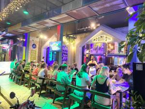 a group of people sitting at a bar with green lights at Moonlight Villa in Phnom Penh