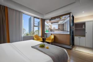 a hotel room with a bed and a kitchen at Morninginn, Malan Mountain Metro in Changsha