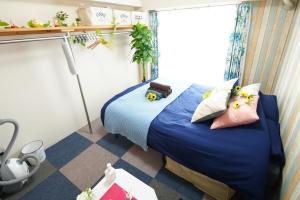 a room with a bed with blue sheets and pillows at Kameari 1003 Budget Stay High Floor Near Station Mall Disney Access in Tokyo