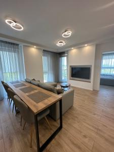 a living room with a table and a couch at Ravėlino Apartment in Klaipėda