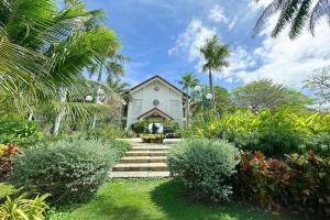 a white house with palm trees and plants at Pax Ana Doc Let Resort & Spa in Ninh Hòa
