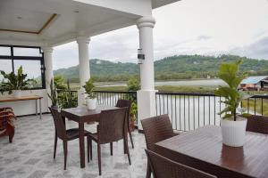 a porch with tables and chairs and a view at Whitehaus BnB in Bais