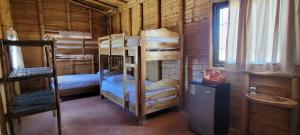 una camera con letti a castello in una cabina di legno di Intilodges Punta Veleros Los Organos a Los Órganos