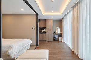 a bedroom with a bed and a living room at Family Hotel & Arbol in Busan
