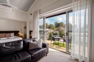 a bedroom with a couch and a large glass window at 107 Apartments Margaret River in Margaret River Town