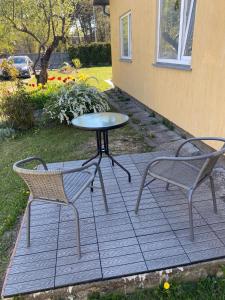 un patio con 2 sedie, un tavolo e un tavolo di Cozy family house a Ventspils