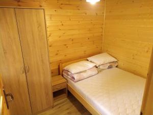 a small room with a bed in a wooden cabin at Domek letniskowy Zełwągi in Zełwągi