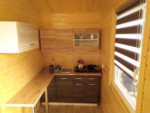 a small kitchen in a log cabin with a sink at Domek letniskowy Zełwągi in Zełwągi