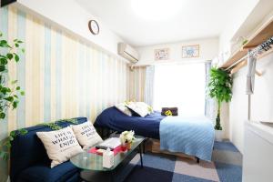 a room with a bed and a couch and a table at SC Kameari 1110 in Tokyo