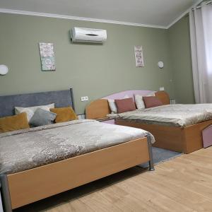 a bedroom with two beds and a couch at Casa Agape in Piteşti