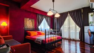 a bedroom with red walls and a bed with orange pillows at Daguli's Home in Anping