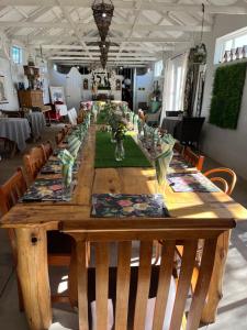 a long wooden table with chairs around it at Die Olyfhuis in Barkly West