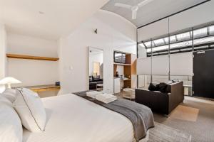 a bedroom with a large bed and a living room at 107 Apartments Margaret River in Margaret River Town