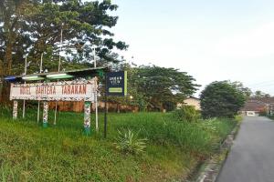 a sign in the grass next to a road at Urbanview Hotel Bahtera Tarakan by RedDoorz in Sibengkok