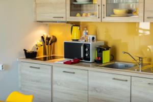 a kitchen with a sink and a microwave at Appartement - Le Soleil des Flots - Vue sur Mer in Crozon