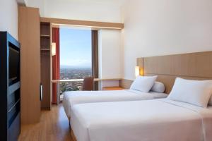 萬隆的住宿－宜必思萬隆一室公寓酒店，酒店客房设有两张床和电视。