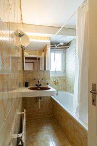 La salle de bains est pourvue d'un lavabo et d'une baignoire. dans l'établissement Jungfrau-View Apartment, terrace & free parking, à Wilderswil