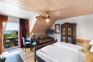 a bedroom with a bed and a desk with a table at Hotel Sonnenstube Hagnau in Hagnau