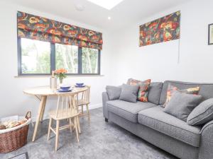 a living room with a couch and a table at Bluebell Cabin in Penrith