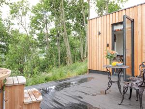 a patio with a table and chairs on a wooden deck at Bluebell Cabin in Penrith