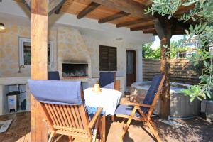 a patio with chairs and a table and a fireplace at HACIENDA MIA extra in Zadar