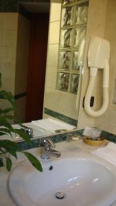 ein Waschbecken mit Spiegel und Telefon in der Unterkunft Hotel Orlanda in Rom