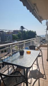 une table et des chaises assises sur un balcon dans l'établissement Seaside Luxury Suites by Sarigianni, à Paralia Katerinis