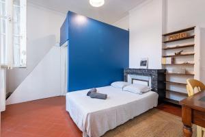 a bedroom with a blue wall and a bed at Le petit marin, clim/wifi/quartier gare-arènes. in Nîmes
