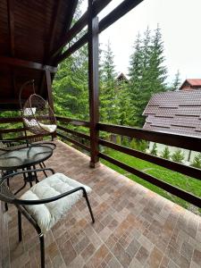 a screened in porch with chairs and a table at Ollie's Mountain Chalet in Buşteni