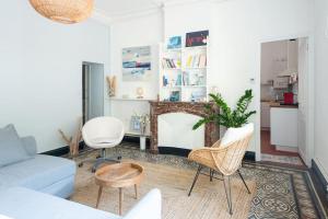 a living room with a couch and chairs and a fireplace at Le petit marin, clim/wifi/quartier gare-arènes. in Nîmes