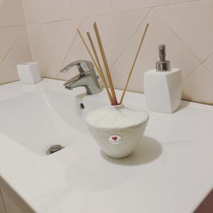 La salle de bains est pourvue d'un lavabo et d'un vase avec des bâtons de bambou. dans l'établissement The Romantic House, à Portoferraio