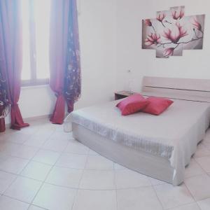 a bedroom with a bed with red pillows on it at The Romantic House in Portoferraio
