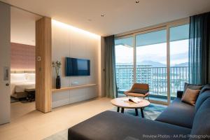 a living room with a couch and a bed and a television at Alma Resort Cam Ranh in Cam Ranh