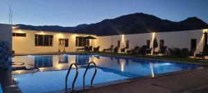 a swimming pool in front of a house at night at THE FORTUNE RESORTS in Leh