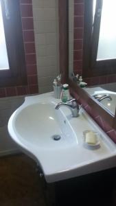 a bathroom with a white sink and a mirror at Il mare cristallino dell'Ogliastra- Marina di Tertenia in Tertenìa