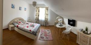 a bedroom with a bed and a desk and a television at Unser Haus in Sibiu