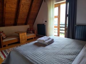 a bedroom with a white bed and a window at Villa Gjeçaj Guesthouse and Restaurant in Theth