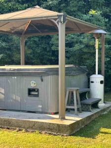 een prieel met een bank en een grill bij Manoir de la Vente de Rouville in Mesnil-Raoul