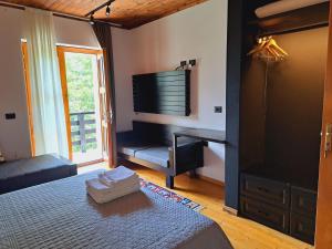 a bedroom with a bed and a television on the wall at Villa Gjeçaj Guesthouse and Restaurant in Theth