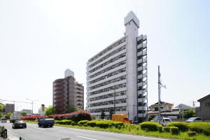 un edificio con una torre de reloj al lado de una carretera en SC Kameari 1003, en Tokio