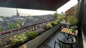 een balkon met een houten tafel en een aantal planten bij BOSTEL 88 - Moderne Stadtwohnung mit Klimaanlage in Moers