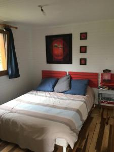 um quarto com uma cama grande e almofadas azuis em Maison entre mer et campagne em Landéda