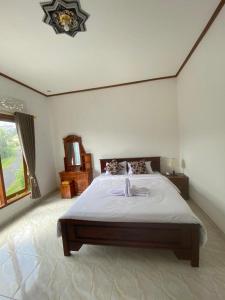 ein Schlafzimmer mit einem großen Bett in einem Zimmer in der Unterkunft Sri Sedana Homestay in Sidemen