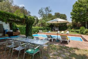 - une table avec des chaises et un parasol à côté de la piscine dans l'établissement Casanova, à Vallromanas