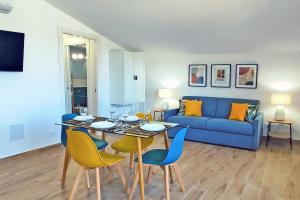 un soggiorno con divano blu, tavolo e sedie di Villa Paradiso a Scopello