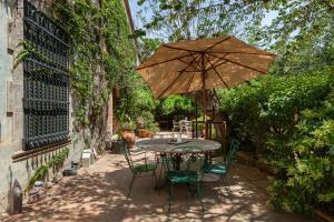 a table and chairs with an umbrella on a patio at Casanova in Vallromanes