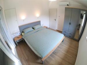 1 dormitorio con 1 cama grande y espejo en Holiday home Brseč, en Mošćenička Draga