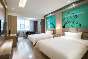Una habitación de hotel con tres camas y un escritorio con un piano. en Morninginn, Xinhua Railway Station, en Xinhua